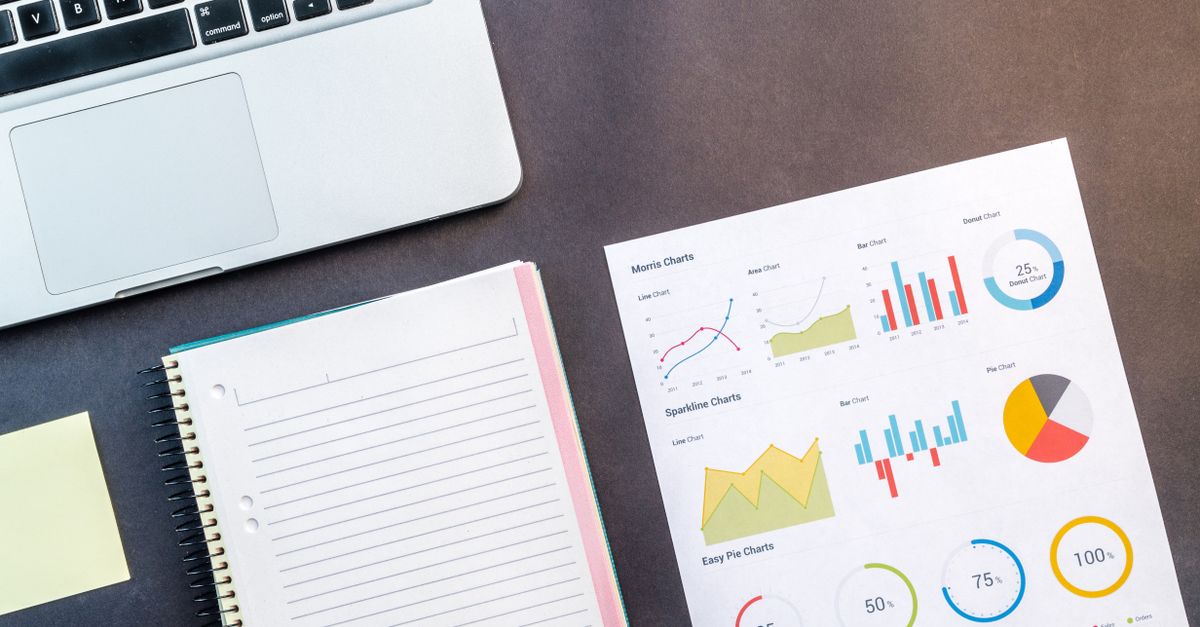 Mesa de trabajo con documentos antiguos, cuadernos y una lupa
